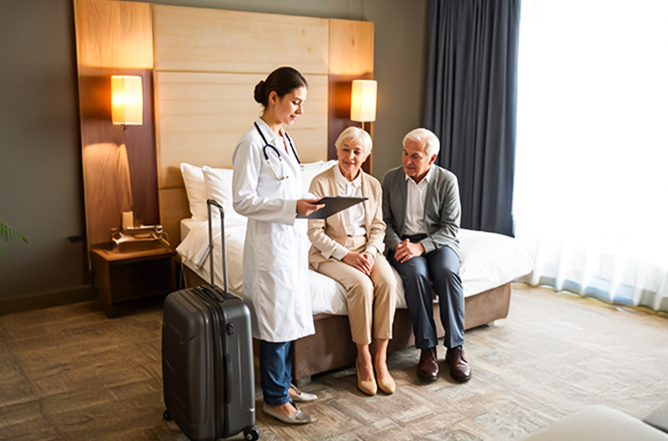 Doctor at hotel in Dubai providing medical consultation to a traveler in a hotel room.